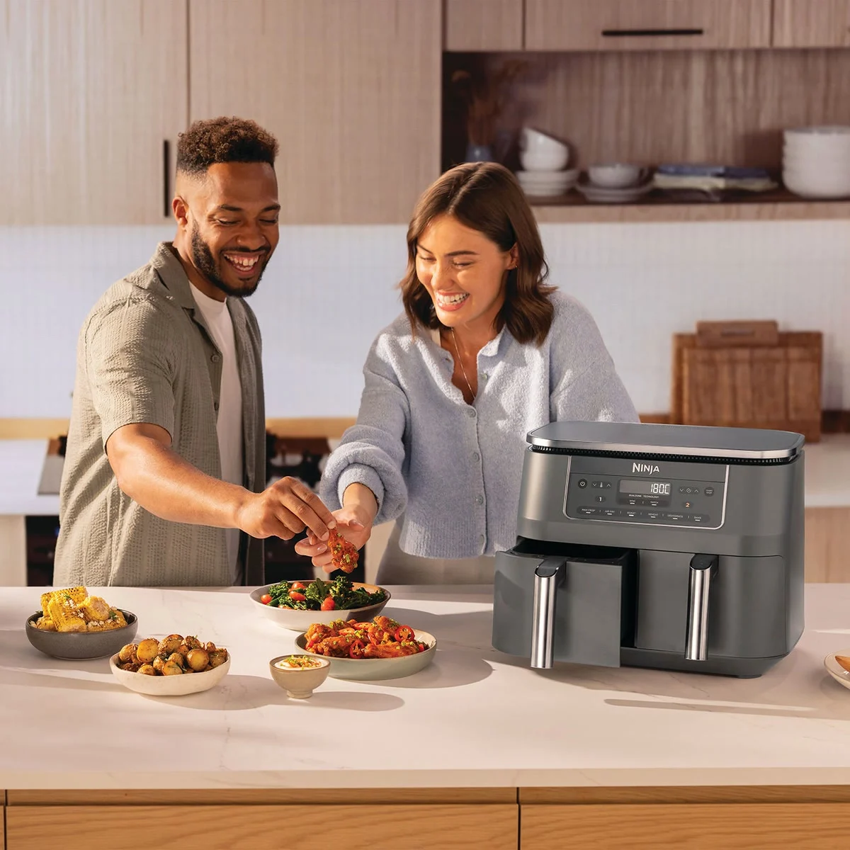 Un couple sert le repas cuit dans le Ninja Dual Zone